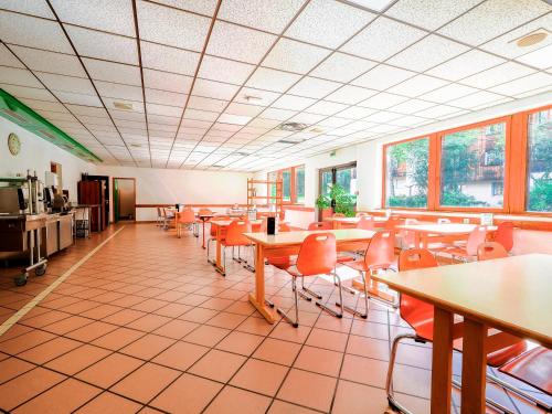夏蒙尼-勃朗峰Auberge de Jeunesse HI Chamonix的用餐室设有桌椅和窗户。