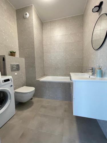 乌涅尤夫Apartamenty Termalne na Długiej 8的浴室配有卫生间水槽和洗衣机。