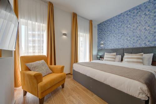 埃尔哥茨拉Marina Suites & apartments - Self catering - by Tritoni hotels的一间卧室配有一张大床和一把椅子
