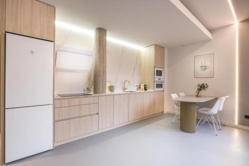 毕尔巴鄂Bilbao Centric Apartments的厨房配有桌子和冰箱