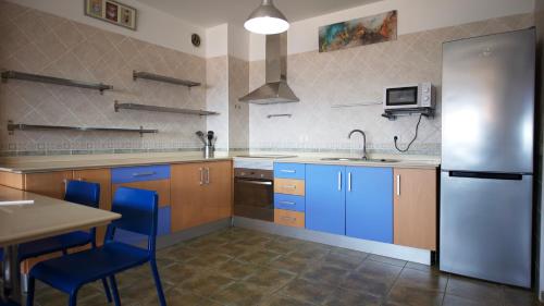 巴尔韦尔德Apartamento en La Caleta El Hierro的厨房配有蓝色橱柜和不锈钢冰箱