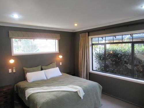 陶朗加Palm Paradise with Spa的一间卧室配有带两个枕头的床和窗户
