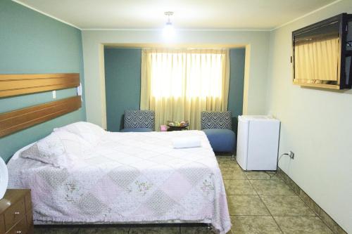 利马帕达玛酒店的卧室配有白色的床和窗户。