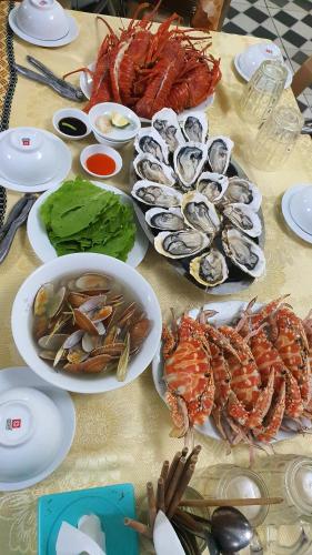 格卢市社Khách sạn Phương Dung的餐桌,上面放着海鲜盘和碗