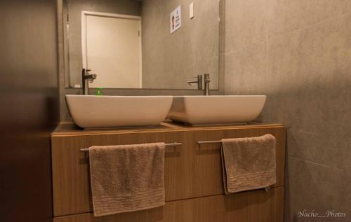 爱妮岛卡姆豪斯旅舍的浴室设有2个水槽、镜子和毛巾。
