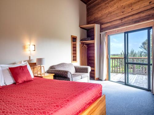 霍基蒂卡闪亮之星海滨酒店的卧室配有红色的床和滑动玻璃门