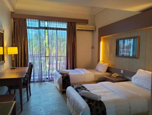 Kampung GurunTHE CLOVE MONT HOTEL的酒店客房配有两张床和一张书桌