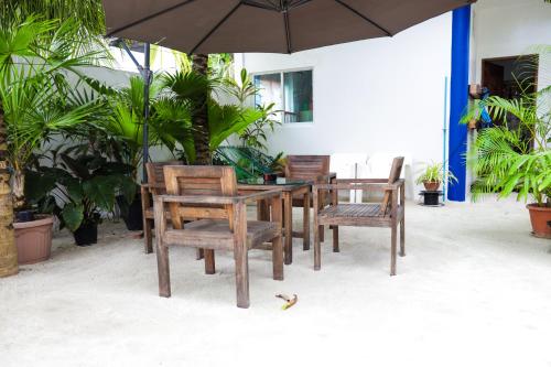 拉斯杜棕榈树旅馆的一张木桌和椅子及雨伞