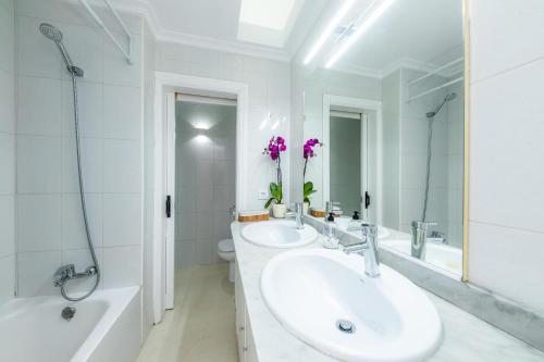 阿尔库迪亚Dolce Vita的白色的浴室设有两个水槽、一个浴缸和一个浴缸。