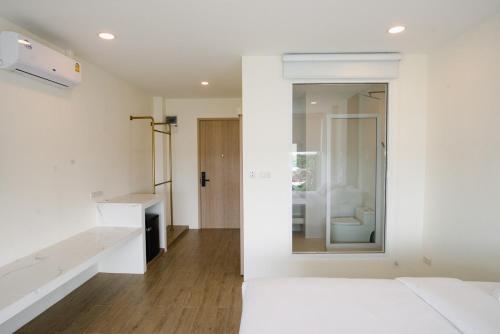 武里南Hotel Agnes的白色的客房配有床和镜子