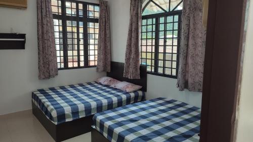 卡庞帕斯班伽克Pangkor Bogar Beach Homestay 邦咯岛民宿的带窗户的客房内的两张单人床