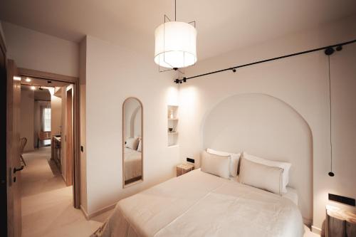 阿菲托斯Om Living Afitos的卧室配有白色的床和镜子