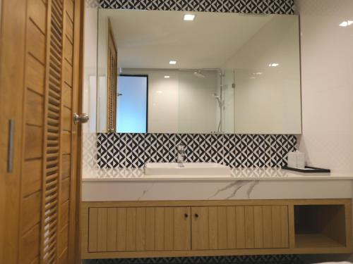 清莱Sann Boutique Hotel的一间带水槽和大镜子的浴室