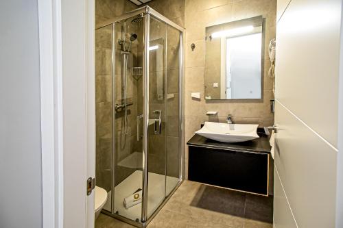 科尔多瓦Apartamentos Ribera 19的一间带玻璃淋浴和水槽的浴室