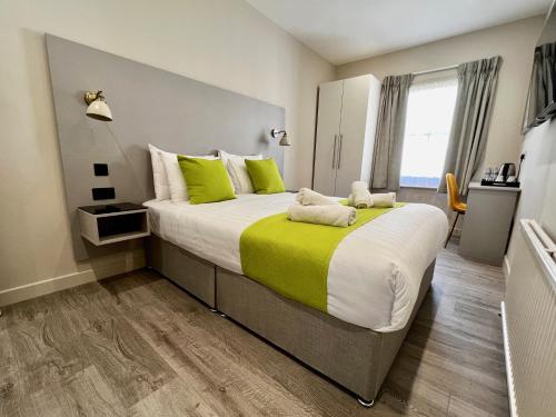 伊斯特布恩Pearl & Pebbles Eastbourne的一间卧室配有一张带绿色和白色枕头的大床