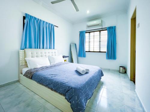 太平Tupai Mas Semi-D by LOUIS的一间卧室配有一张蓝色墙壁和蓝色窗帘的床