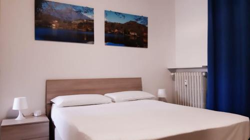 伊夫雷亚Apartment "Borgo Olivetti"的卧室配有一张墙上有两张照片的床。