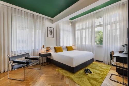 特拉维夫Theodor Brown Rothschild Tel-Aviv, a member of Brown Hotels的卧室设有白色的床和绿色的天花板。