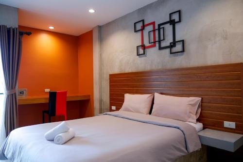 洛坤府B3酒店的卧室配有一张白色大床和木制床头板