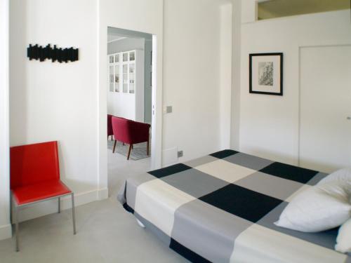 马德里ATOCHA MUSEOS的一间卧室配有一张床和一张红色椅子