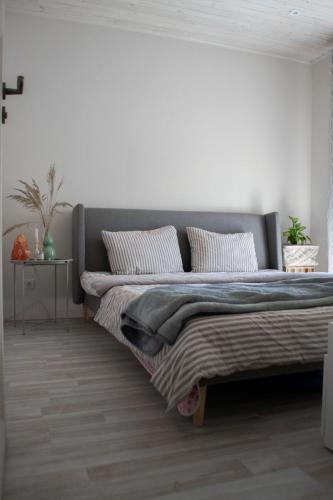 希卢泰Apartamentai Šilutėje的卧室配有一张带白色墙壁的大床