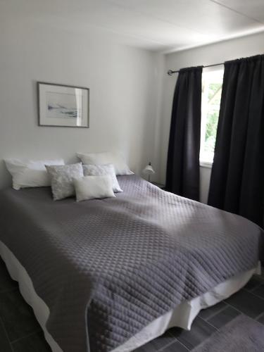 莫斯Huset i skogen的一间卧室配有一张大床和黑色窗帘
