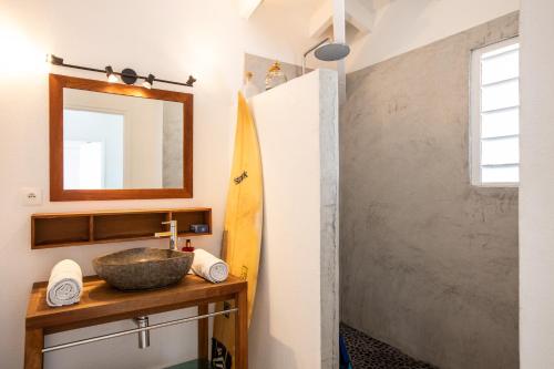 圣马丁岛LIFE IS GOOD IN CUL DE SAC的一间带水槽、镜子和冲浪板的浴室