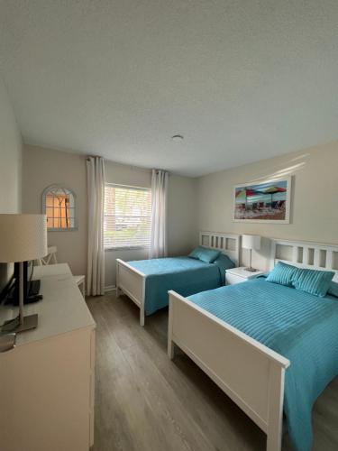 布雷登顿Superb Apartment in Florida & very close to IMG的一间卧室设有两张床、一张桌子和一个窗口。