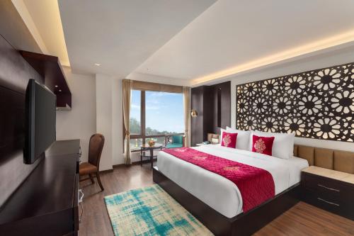 甘托克Ramada by Wyndham Gangtok Hotel & Casino Golden的酒店客房,配有床和电视