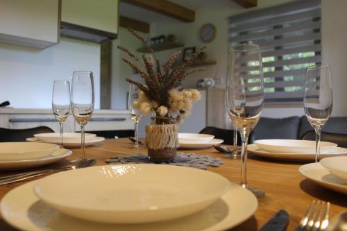 兹雷切Apartment Bajta - Rogla的一张木桌,上面有盘子和玻璃杯