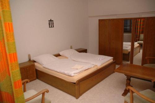 Jüchen尼克劳斯克勒斯特酒店的卧室配有1张床、1张桌子和1把椅子