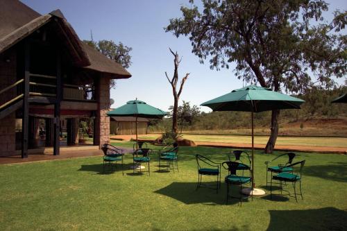 卡利南Zebra Nature Reserve的院子里的一组椅子和遮阳伞