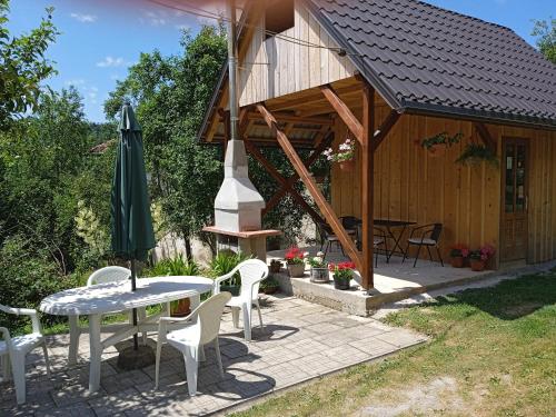 Brod na KupiKuća za odmor Lešnica的房屋配有桌椅和遮阳伞