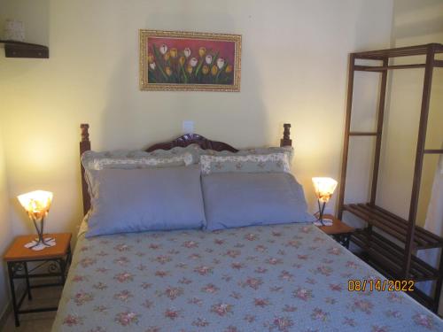 佩尼多Janela dos Meus Sonhos的一间卧室配有一张带蓝色枕头的床和两盏灯。