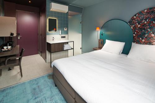 海尔许霍瓦德Hotel Babylon Heerhugowaard - Alkmaar的一间带大床的卧室和一间浴室