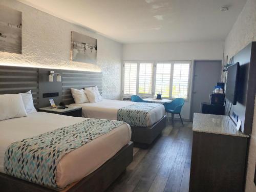 巴拿马城海滩Casa Loma Panama City Beach - Beachfront的酒店客房配有两张床和一张书桌