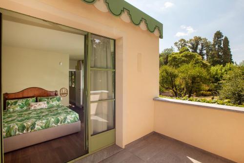科莫The Greenhouse Luxury Villa on Lake Como的阳台设有床和玻璃门