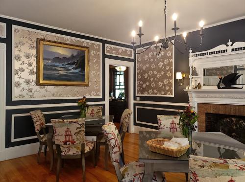 巴港Sand Bar Cottage Inn的一间带桌椅和壁炉的用餐室
