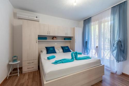 斯坦尼奇Family friendly apartments with a swimming pool Stanici, Omis - 18676的卧室配有带蓝色枕头的大型白色床