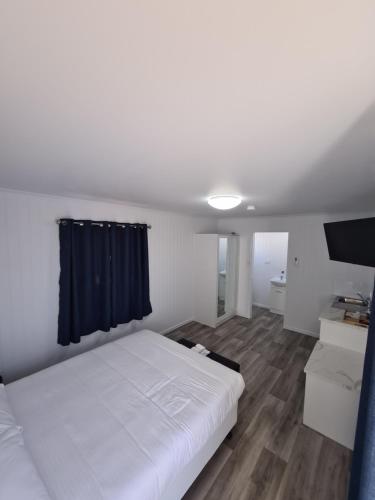 DulaccaThe Dulacca Hotel的卧室配有白色的床和平面电视。