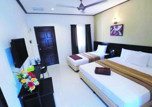珍南海滩安贞别墅酒店的酒店客房设有两张床和电视。