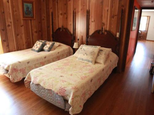 莫罗贝Ocean's Breeze, 4/bed, 3/ba, Game Room. Sleeps 10!的配有木墙和木地板的客房中的两张床