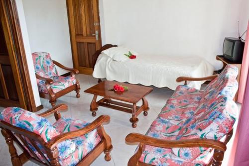 博瓦隆玫瑰别墅的客厅配有椅子、床和桌子
