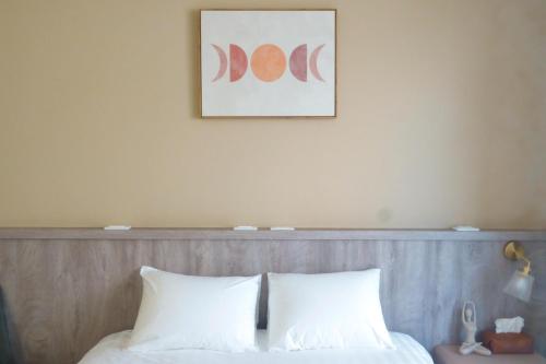 台东宿嘻民宿的一张带两个白色枕头的床和一张墙上的照片