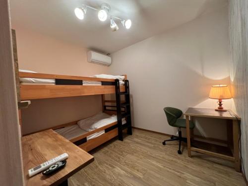直岛町直岛背包客旅馆的客房设有双层床和一张带台灯的书桌。