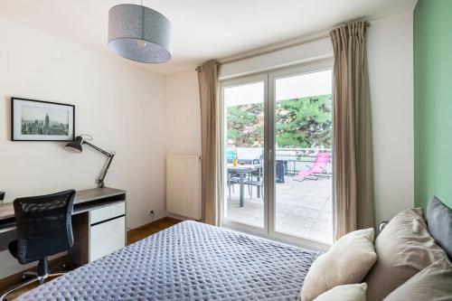 斯特拉斯堡Comme chez vous的一间卧室配有一张床、一张书桌和一个窗户。