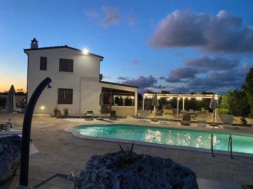 卡尔皮尼亚诺萨伦蒂诺Agriturismo Masseria Saittole的黄昏时带游泳池的别墅