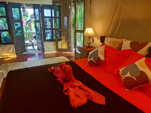 罗威那芳科宫酒店的一间卧室配有一张带红色床单和枕头的床。
