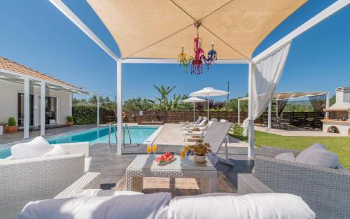 VanátonMadini Luxury villa with private heated pool的一个带桌椅的庭院和一个游泳池