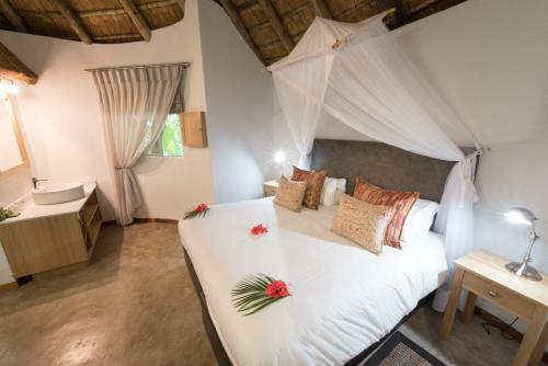 帕拉博鲁瓦赛非派旅行旅舍的卧室配有带鲜花的白色床